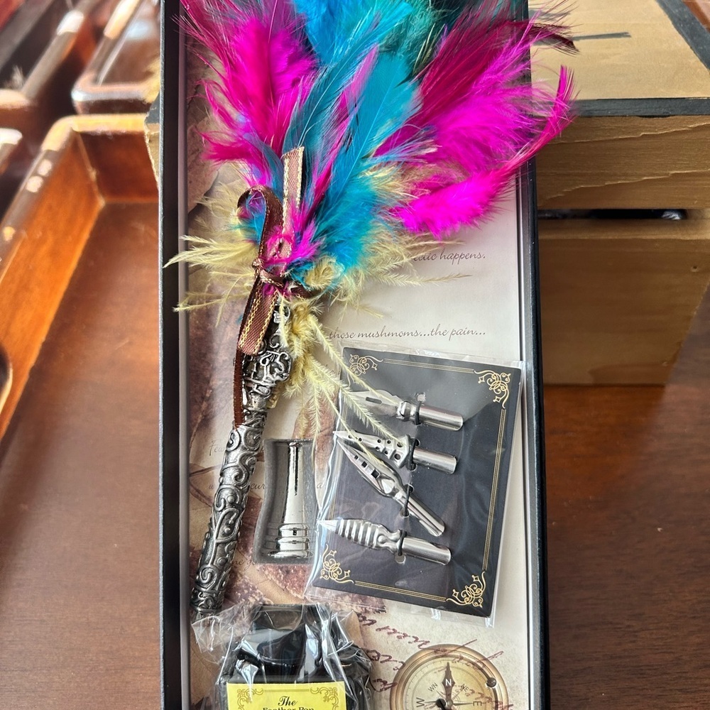 Colorful feather quill with nibs, ink and more